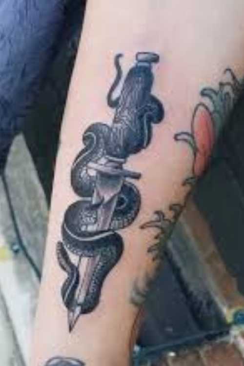 dagger and snake tattoo in Forearm
